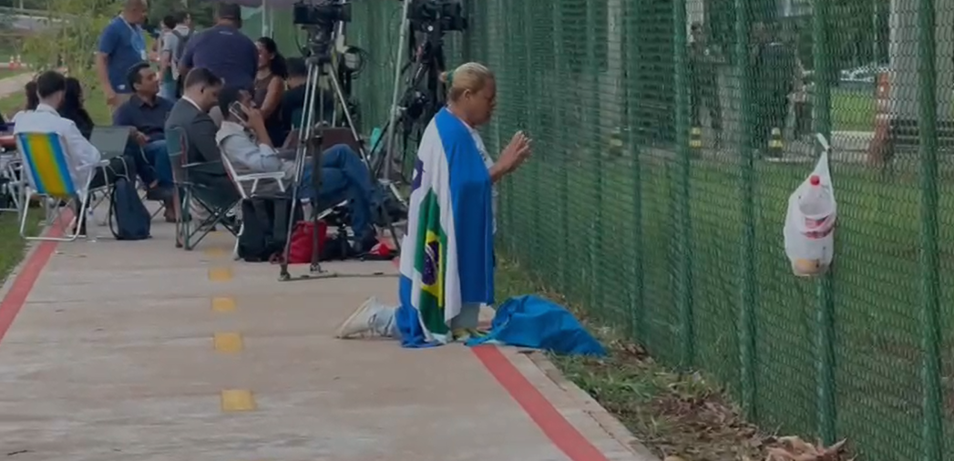Exclusivo: Mulher se ajoelha em frente à PF e reza por Bolsonaro