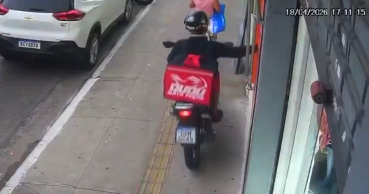 Falso entregador sobe na calçada com moto e rouba celular de mulher na porta de loja