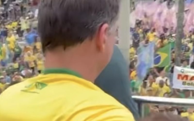 Ao lado de esposa, Flávio Bolsonaro acena para apoiadores