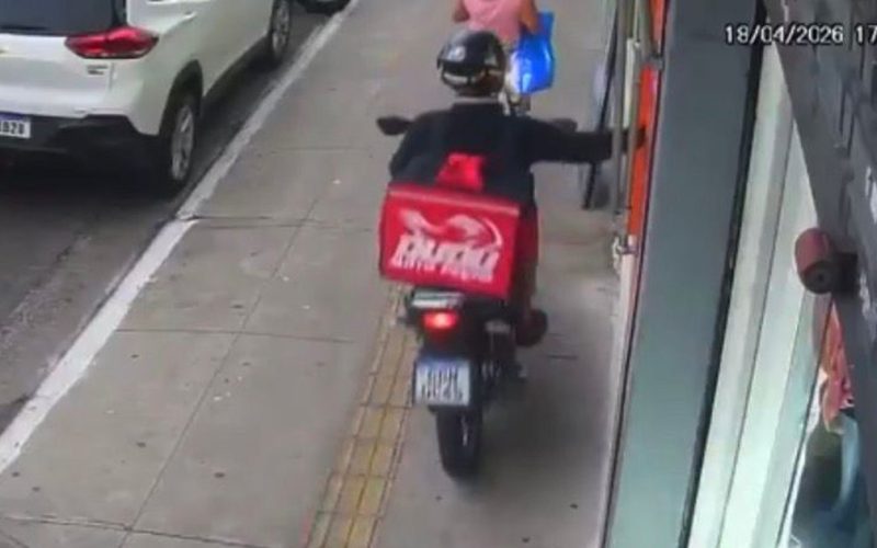 Falso entregador sobe na calçada com moto e rouba celular de mulher na porta de loja