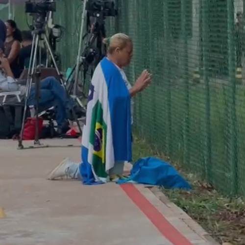 Exclusivo: Mulher se ajoelha em frente à PF e reza por Bolsonaro